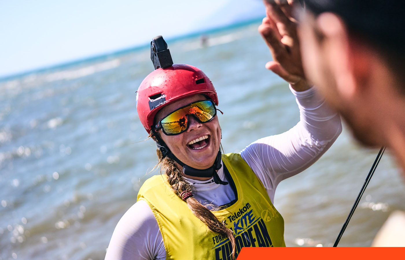 Jessie Kampman geeft lachend een high five na de race bij het EK kitefoilen